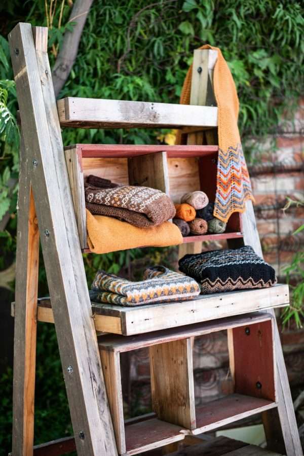 Stack of knits outside on a wooden ladder